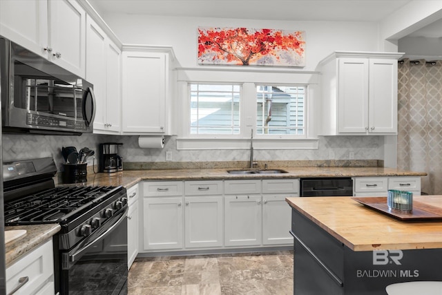 kitchen featuring sink, black appliances, white cabinets, and decorative backsplash