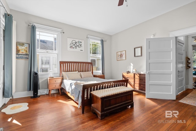 bedroom featuring multiple windows, wood-type flooring, and ceiling fan