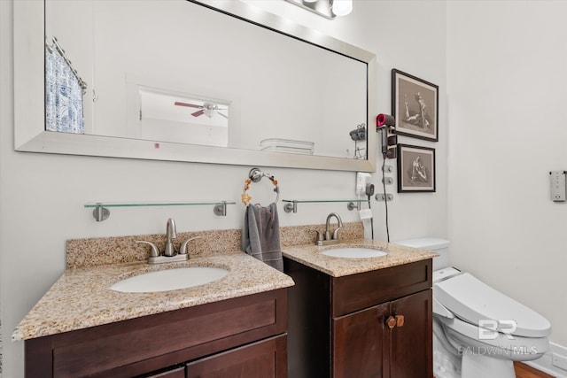 bathroom with vanity, toilet, and ceiling fan