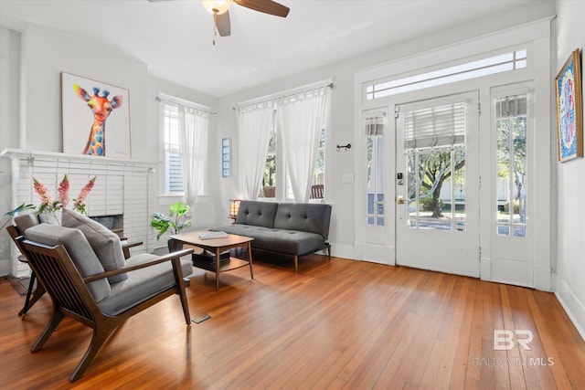 sitting room featuring hardwood / wood-style flooring, a fireplace, and ceiling fan