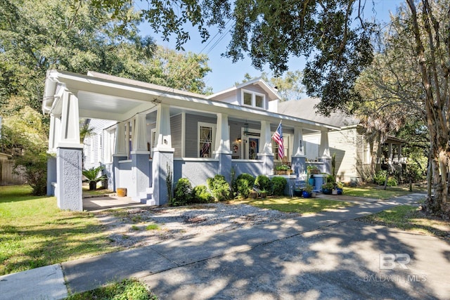 view of front facade with a porch, a front yard, and a carport