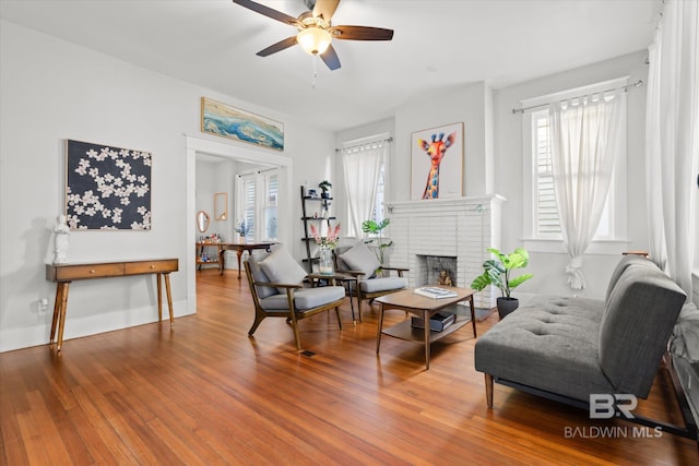 living room featuring a fireplace, hardwood / wood-style flooring, and ceiling fan