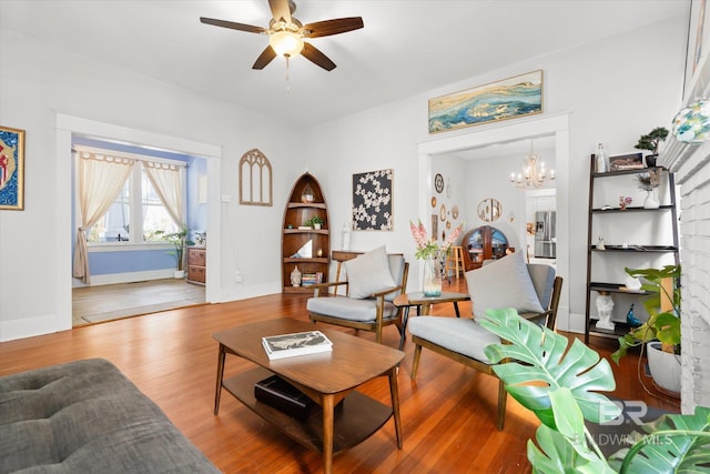 living room featuring hardwood / wood-style flooring and ceiling fan with notable chandelier