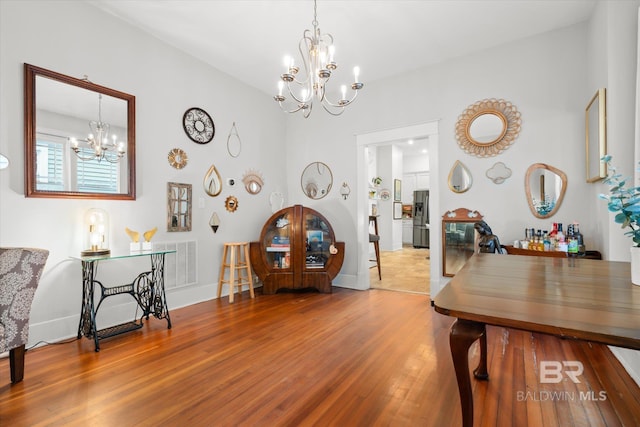 dining area with a notable chandelier and hardwood / wood-style flooring