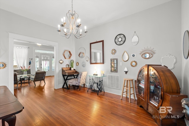 interior space with a notable chandelier and hardwood / wood-style flooring