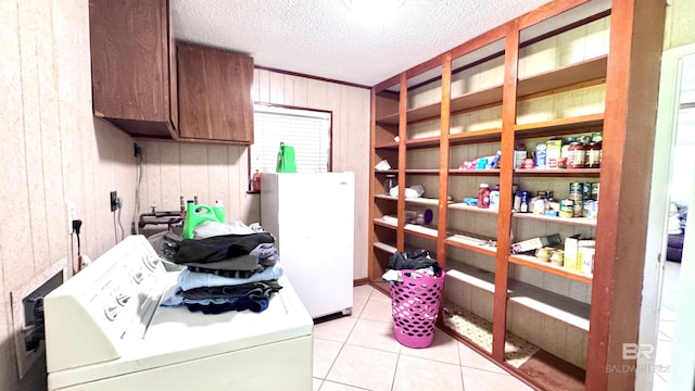 615 Pedigo Ave, Foley, AL 36535 - clothes washing area featuring washing machine and clothes dryer, wood walls, cabinet space, a textured ceiling, and light tile patterned floors