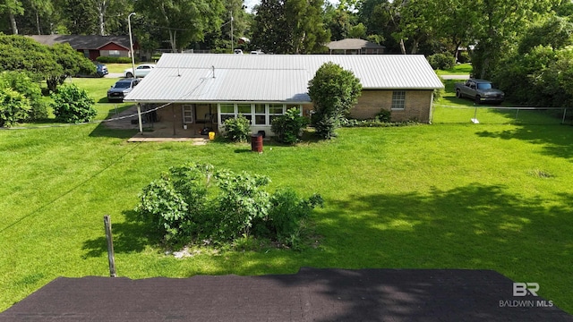 615 Pedigo Ave, Foley, AL 36535 - back of house featuring metal roof, brick siding, and view of scattered trees