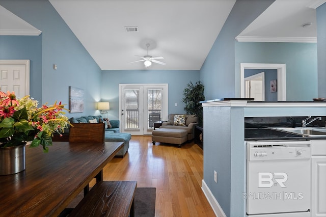 interior space featuring ceiling fan, lofted ceiling, visible vents, ornamental molding, and light wood finished floors