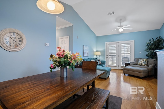 dining room featuring lofted ceiling, ceiling fan, visible vents, and light wood-style floors