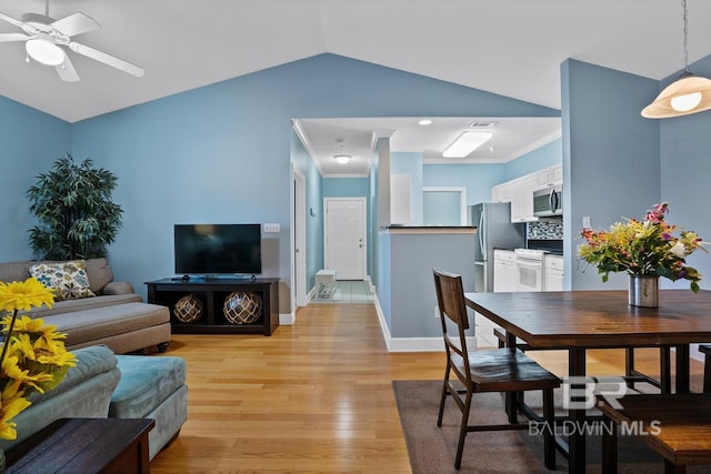 dining room with crown molding, lofted ceiling, a ceiling fan, light wood-type flooring, and baseboards