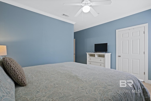 carpeted bedroom featuring ceiling fan, visible vents, and ornamental molding