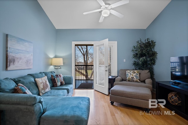 living room with ceiling fan, vaulted ceiling, and wood finished floors