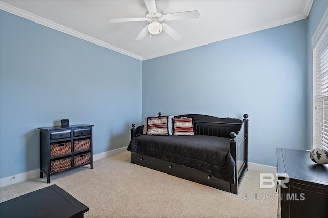 carpeted bedroom featuring ornamental molding, ceiling fan, and baseboards