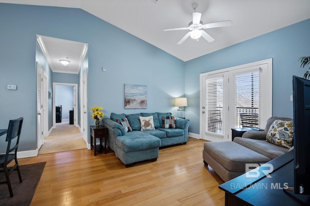 living area with lofted ceiling, ornamental molding, a ceiling fan, light wood-type flooring, and baseboards