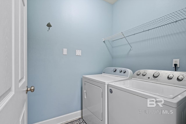 laundry area with laundry area, independent washer and dryer, and baseboards