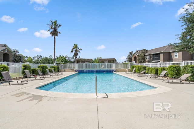 pool with a patio area and fence