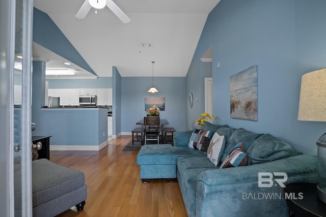 living area featuring light wood-type flooring, visible vents, ceiling fan, and baseboards