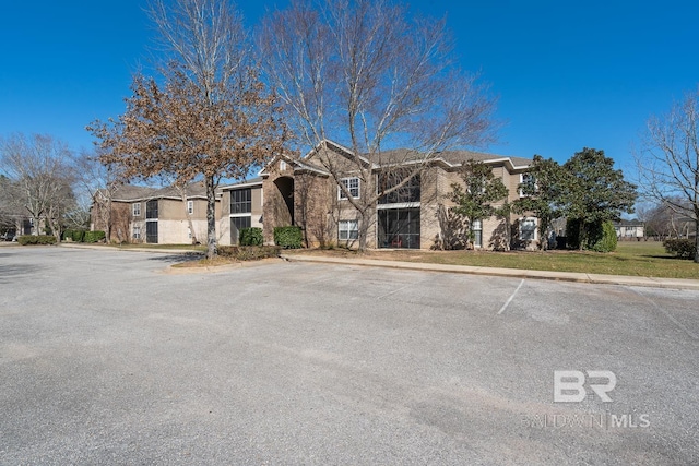 view of front of property featuring uncovered parking and brick siding