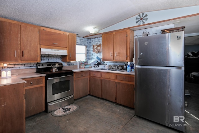 kitchen featuring vaulted ceiling, decorative backsplash, appliances with stainless steel finishes, and a textured ceiling