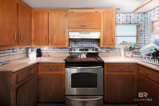 kitchen with decorative backsplash, a textured ceiling, and stainless steel electric stove