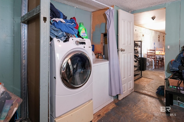 washroom featuring a textured ceiling and washer and dryer