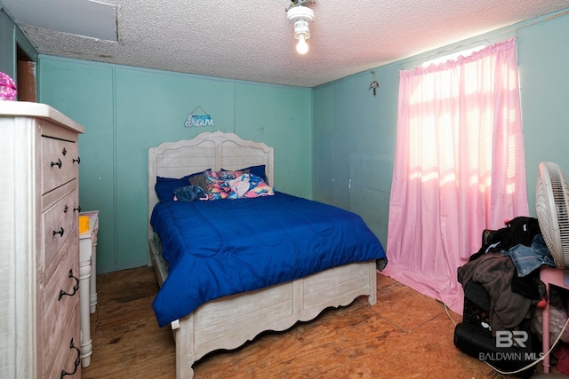 bedroom featuring wood-type flooring and a textured ceiling