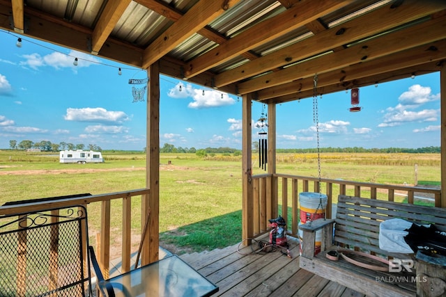 deck with a rural view and a lawn