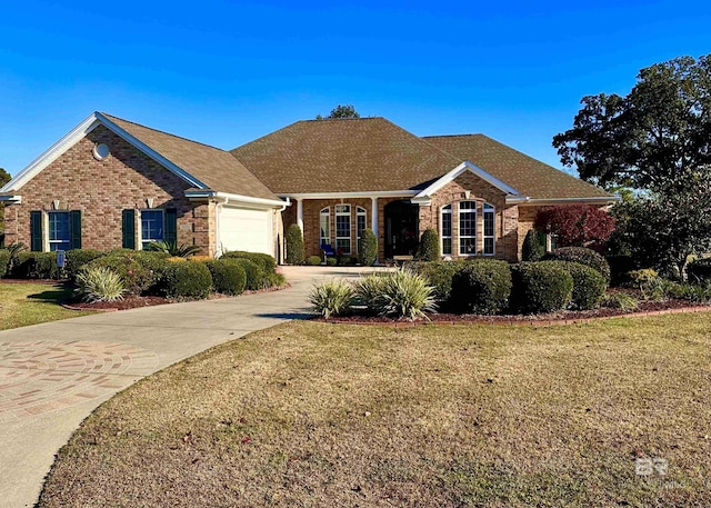 single story home with concrete driveway, brick siding, an attached garage, and a front yard