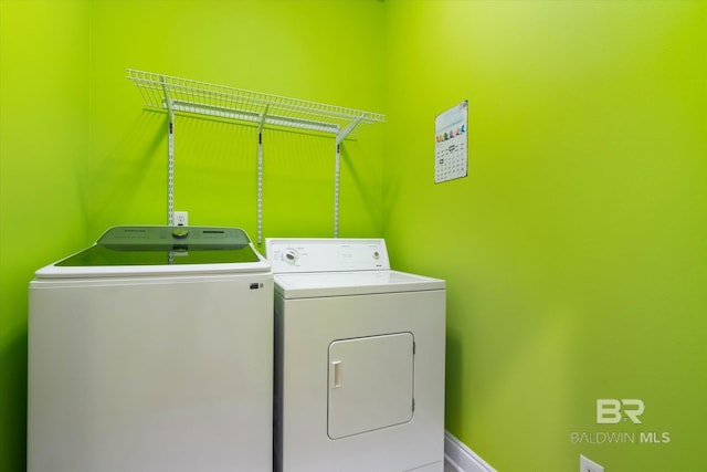 laundry room with washing machine and clothes dryer, baseboards, and laundry area