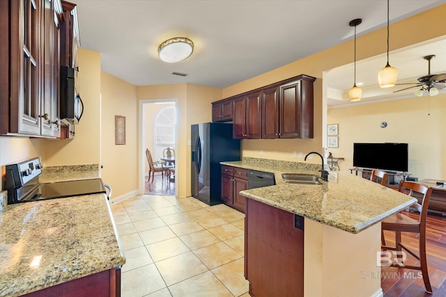 kitchen featuring a sink, a breakfast bar, stainless steel range with electric stovetop, a peninsula, and visible vents