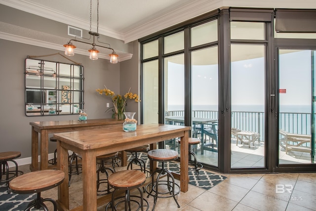 dining space with light tile patterned floors, visible vents, a water view, and ornamental molding