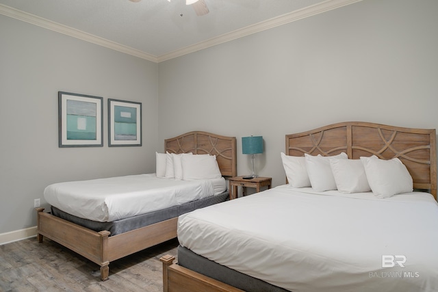 bedroom featuring ceiling fan, crown molding, baseboards, and wood finished floors