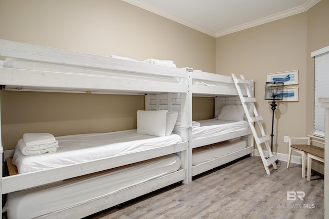 bedroom featuring crown molding, baseboards, and wood finished floors