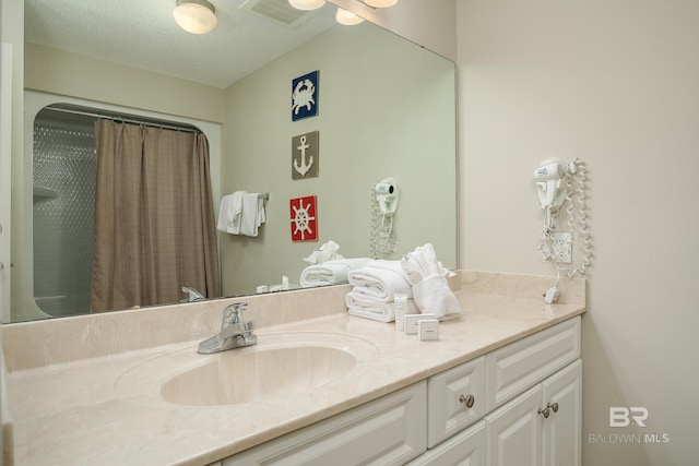 bathroom featuring vanity, visible vents, and a textured ceiling