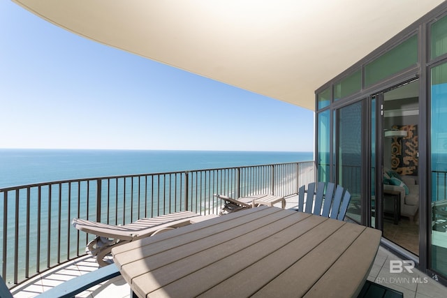 balcony featuring outdoor dining area and a water view