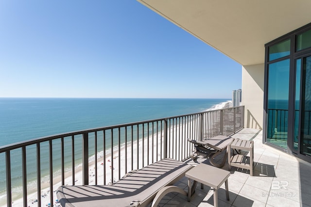 balcony featuring a beach view and a water view