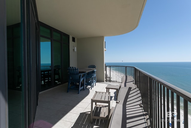 balcony featuring visible vents, a water view, and a beach view