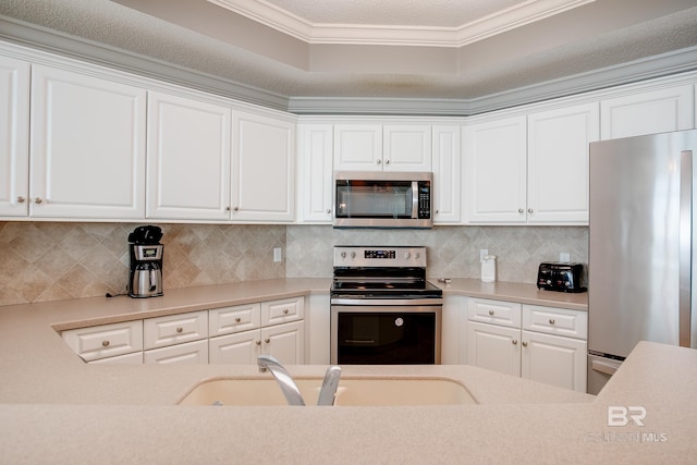 kitchen with decorative backsplash, white cabinets, stainless steel appliances, and a sink