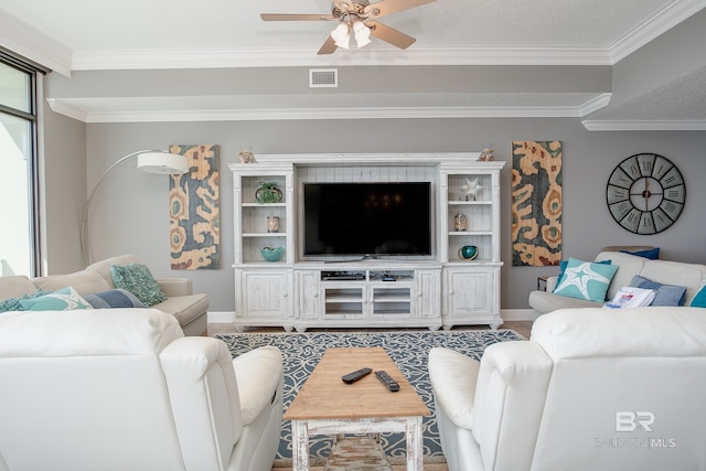 living area with visible vents, ornamental molding, and a ceiling fan