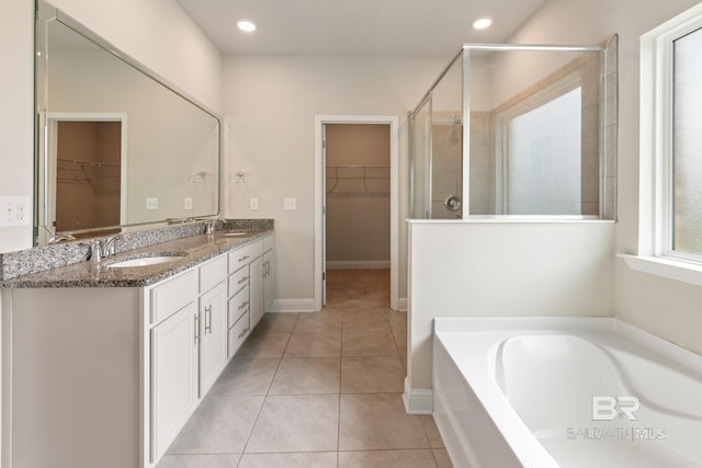 bathroom featuring tile patterned flooring, a walk in closet, and a sink