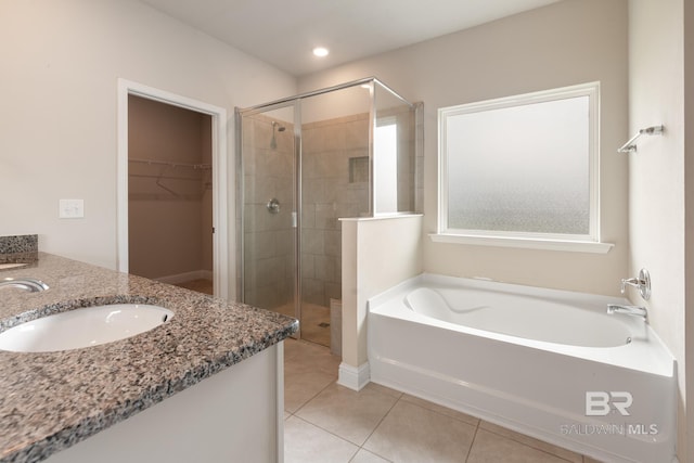 bathroom with vanity, a spacious closet, a bath, tile patterned floors, and a stall shower