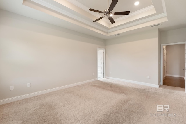 unfurnished room with baseboards, visible vents, a raised ceiling, and crown molding