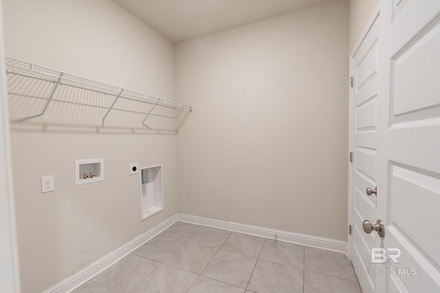 clothes washing area featuring light tile patterned floors, hookup for a washing machine, hookup for an electric dryer, laundry area, and baseboards