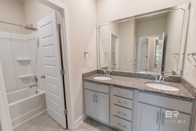 bathroom featuring shower / washtub combination, double vanity, a sink, and tile patterned floors