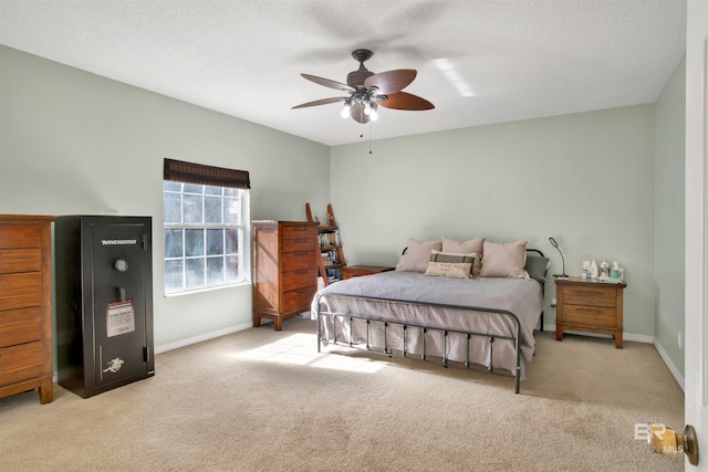 bedroom featuring light carpet, a textured ceiling, and ceiling fan