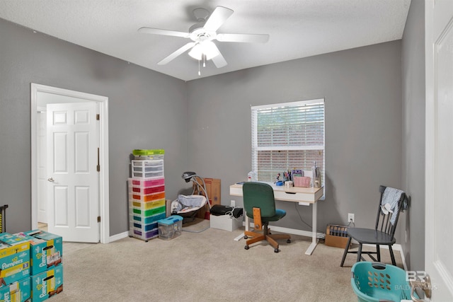 carpeted office featuring ceiling fan and a textured ceiling