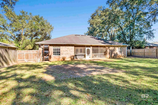 rear view of house with a lawn and a sunroom