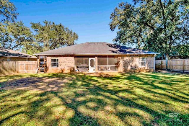 back of property featuring a sunroom and a yard