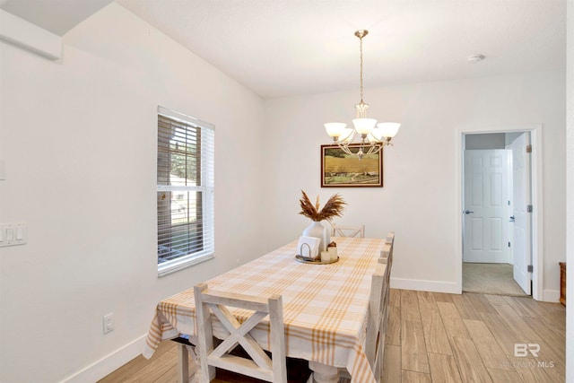 dining room with light wood-type flooring and a notable chandelier