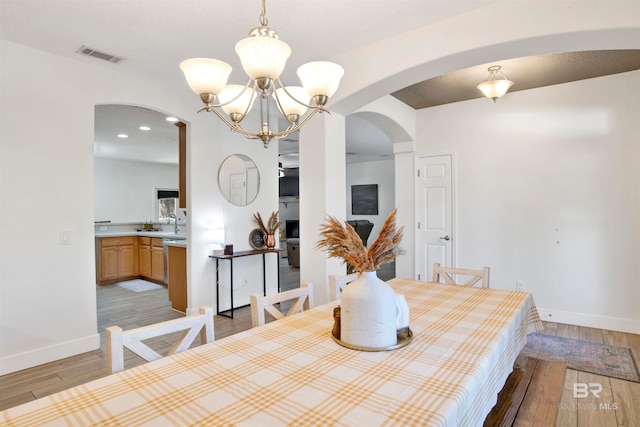 dining area with an inviting chandelier and light hardwood / wood-style flooring